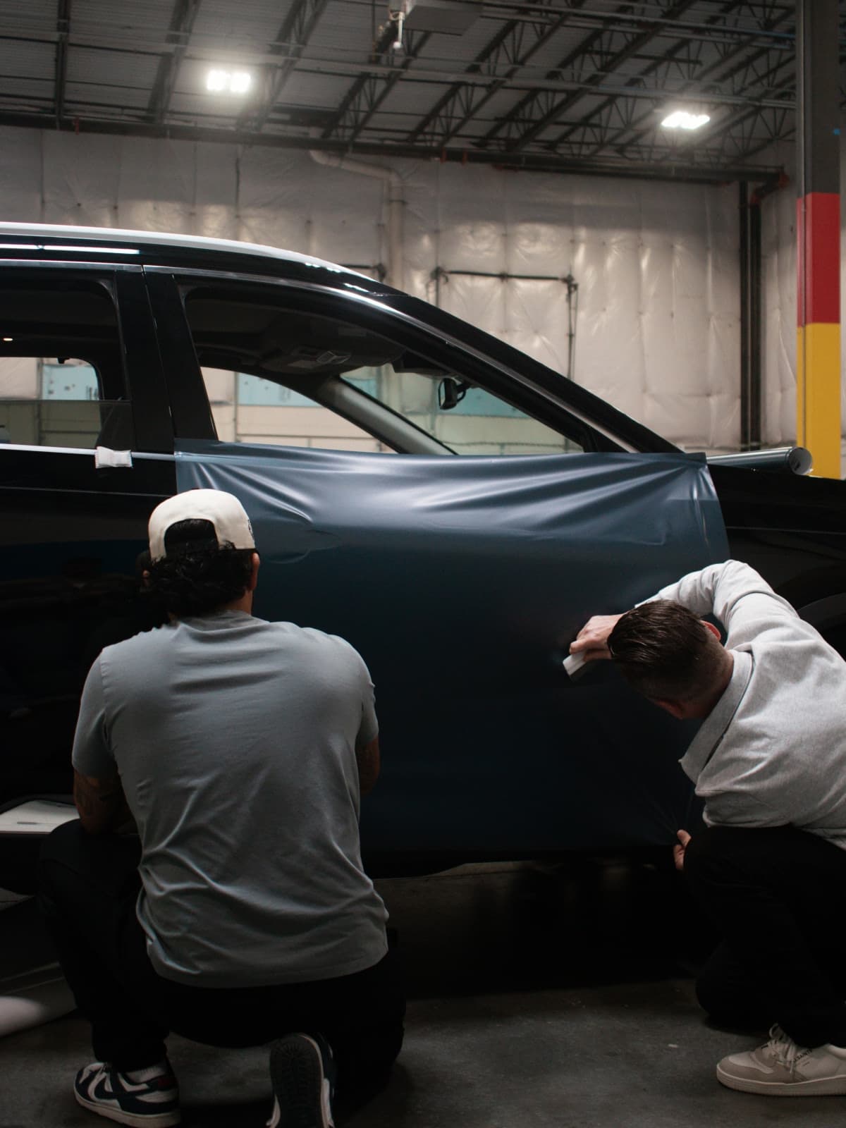 Installers applying vinyl wrap in the shop